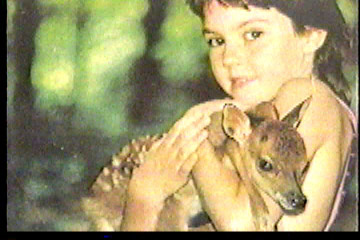A young girl holding a fawn