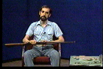 Steve in studio, holding up gun.