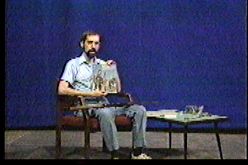 Steve in studio, holding up an old issue of The American Rifleman magazine