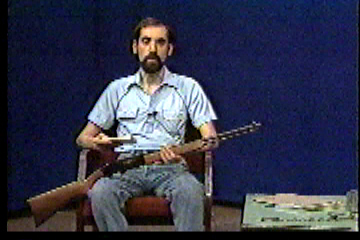Steve in studio with gun in his lap.