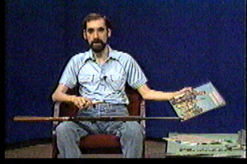 Steve in studio, holding up an old issue of The American Rifleman magazine