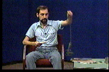 Steve in studio, holding up a leg-hold trap