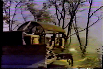 A bulldozer pulling down trees