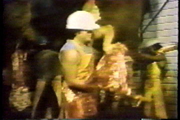 A butcher holding a head he had just cut off.