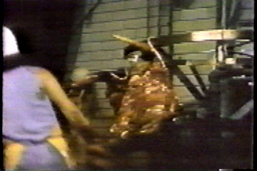 The butcher hangs the decapitated head on a hook.