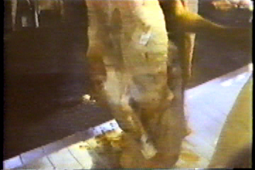 A butcher cutting open the carcas of a cow: its insides spillout out onto the slaughterhouse floor.